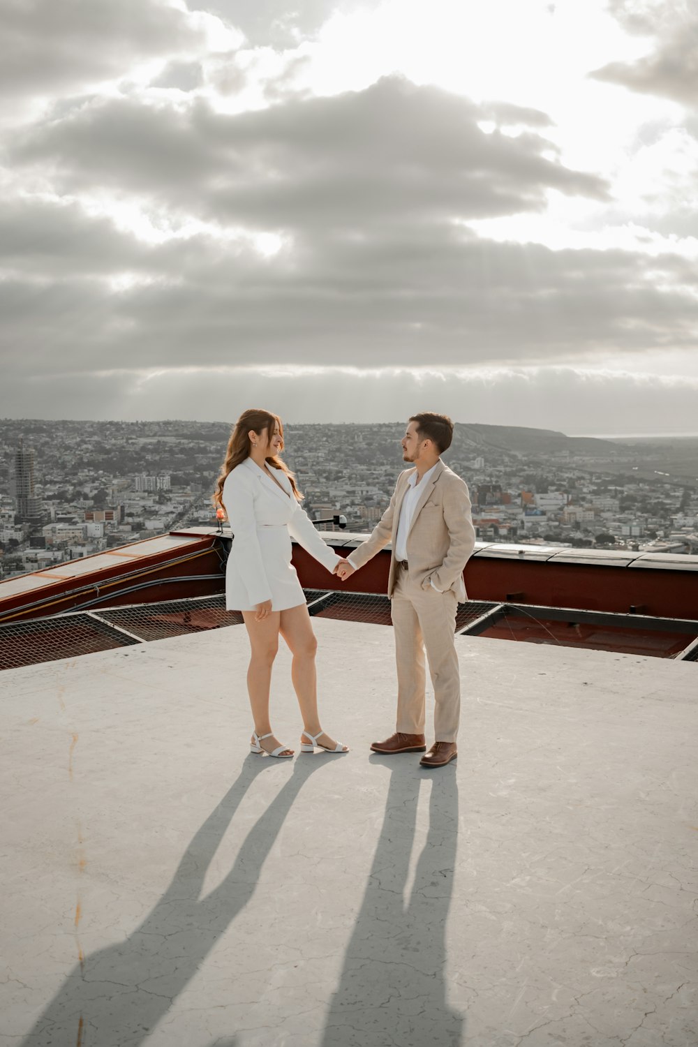 a man and a woman standing on top of a building