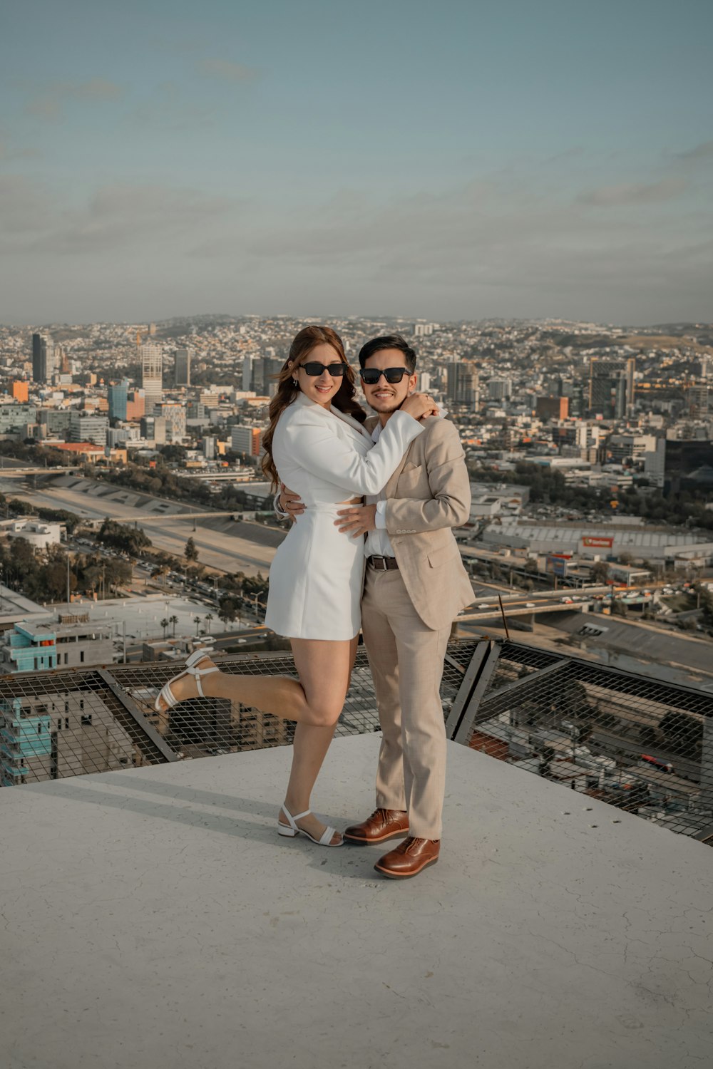 a man and woman standing on top of a building