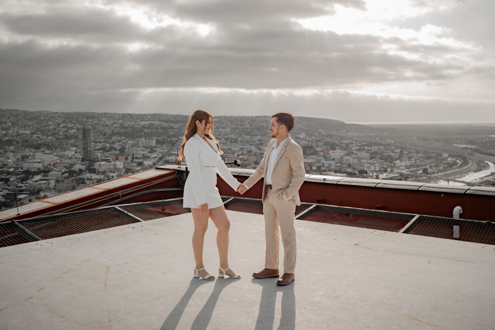 a man and a woman standing on top of a building