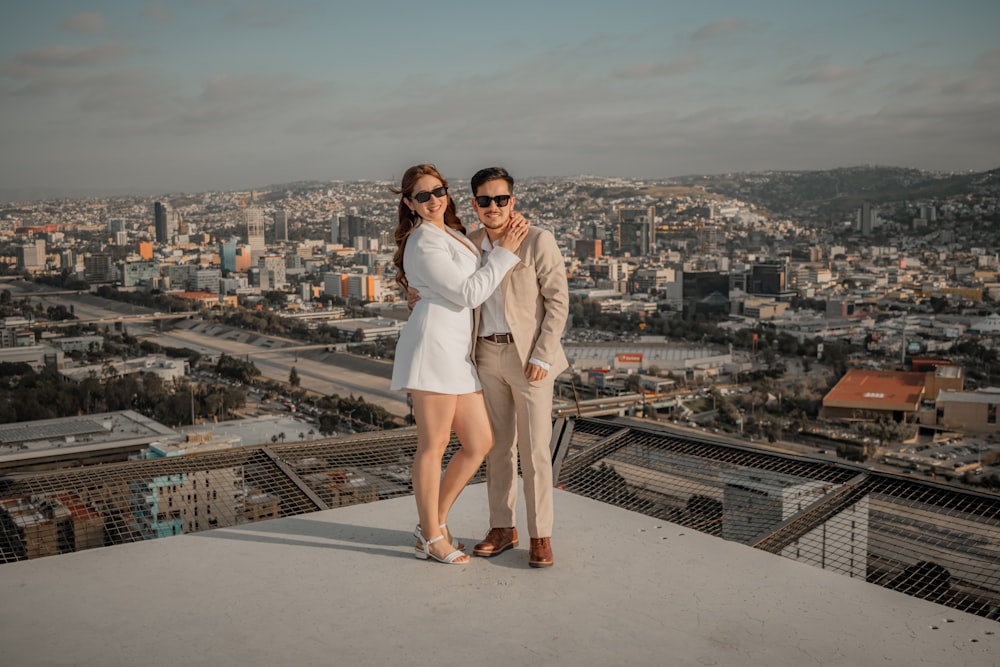 a man and a woman standing on top of a building