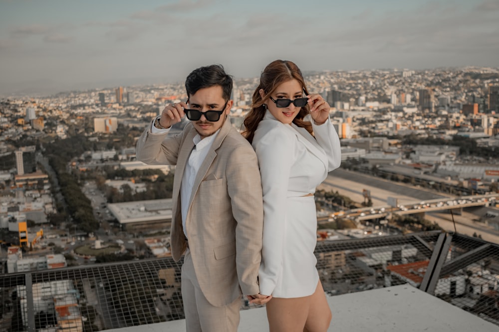 a man and a woman standing on top of a building