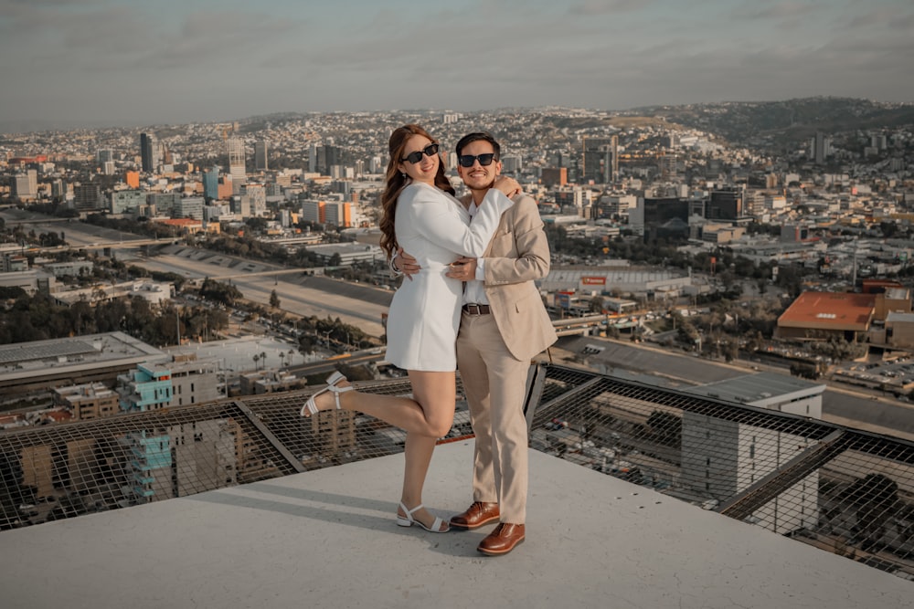 a man and a woman standing on top of a building