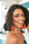 a woman with orange earrings smiling at the camera