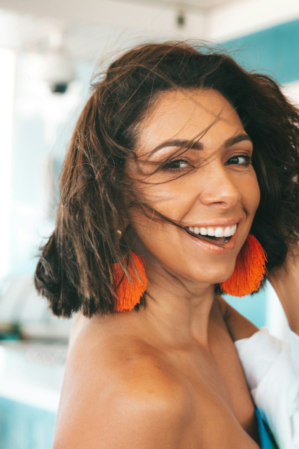 a woman with orange earrings smiling at the camera