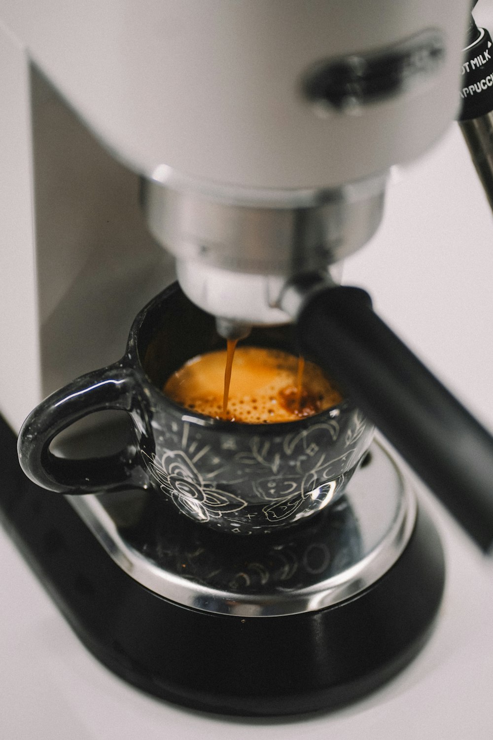 a coffee maker pouring a cup of coffee