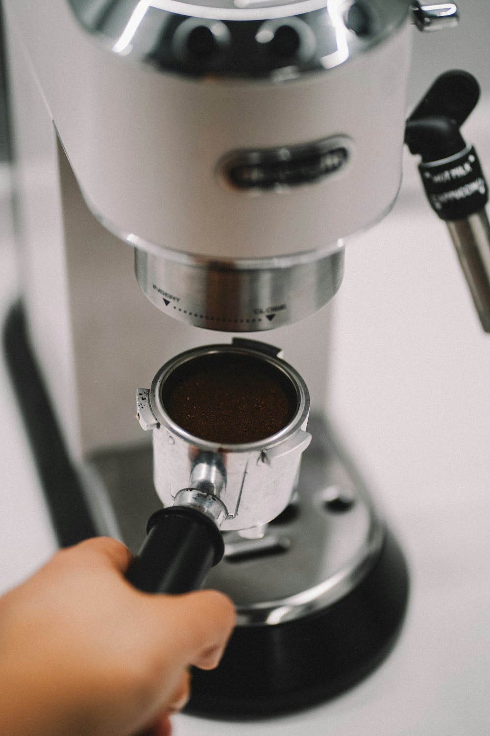 a person is using a coffee maker to make a cup of coffee