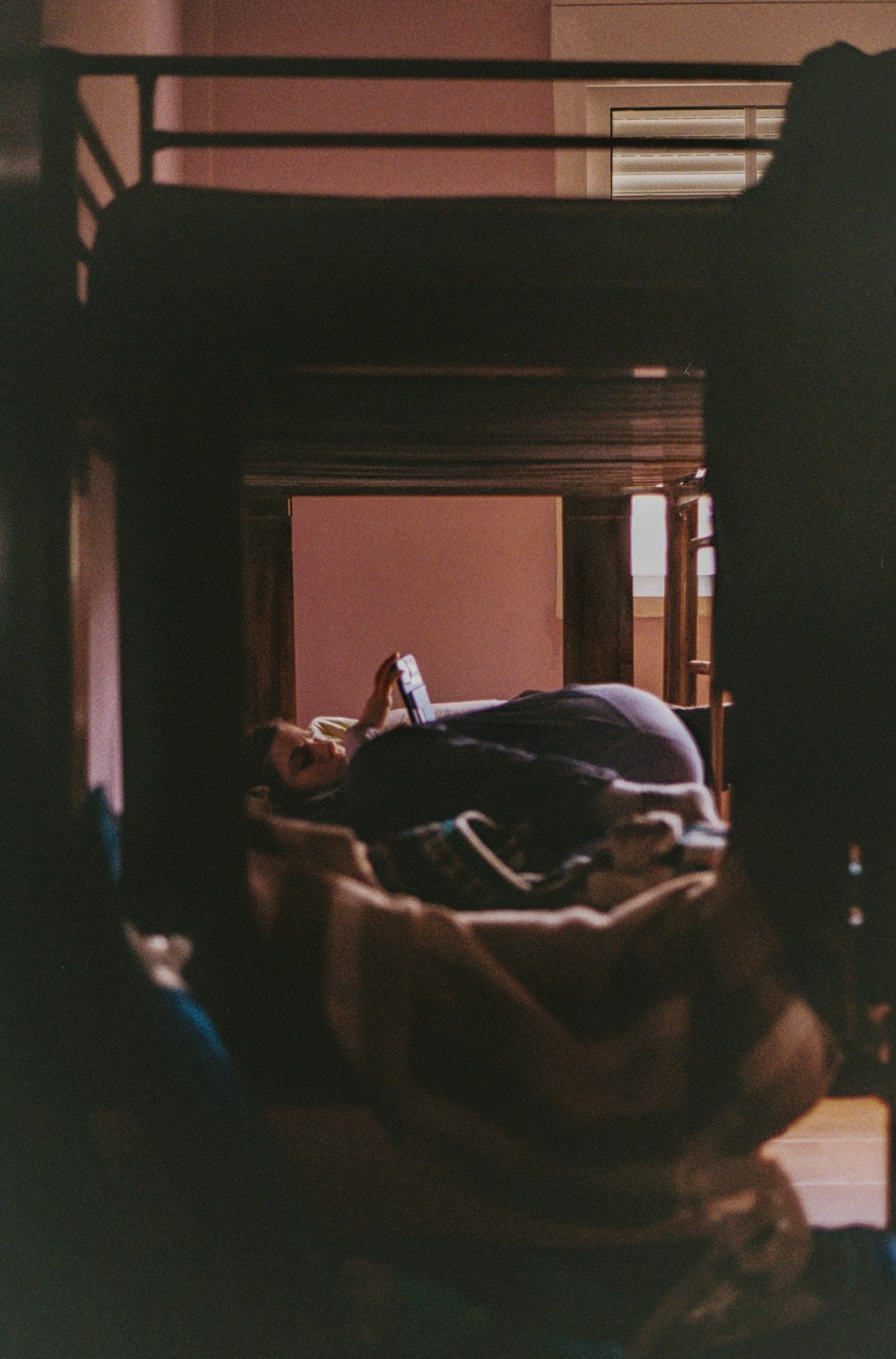 a person laying in a bed under a bunk