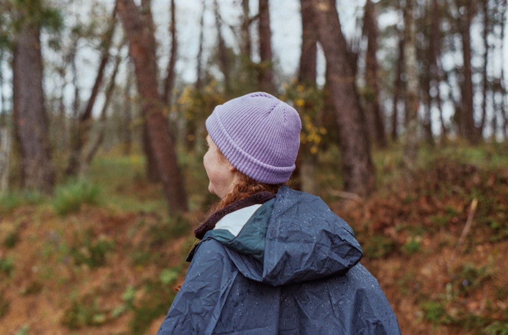 a woman in a blue jacket and a purple hat