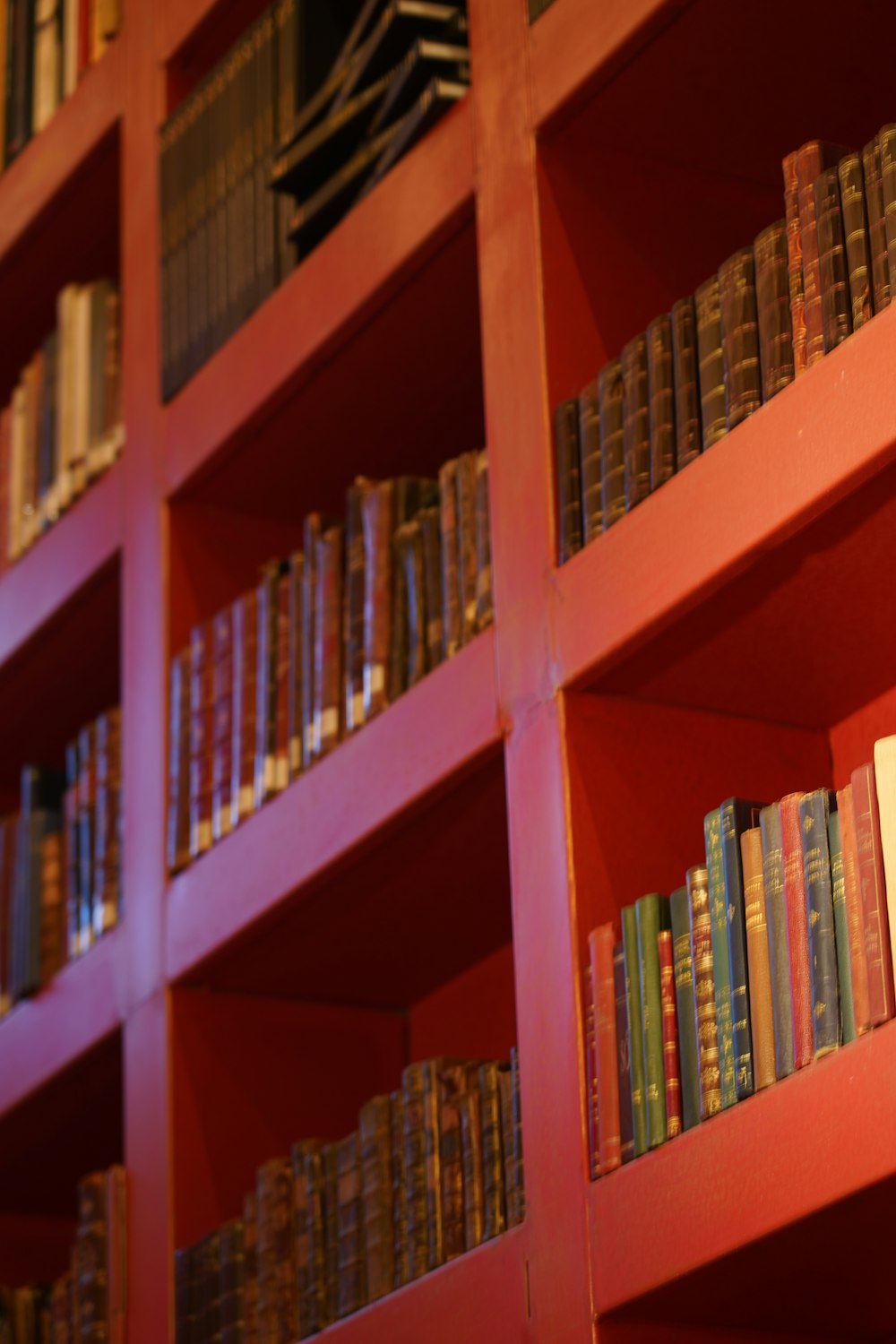 a red book shelf filled with lots of books