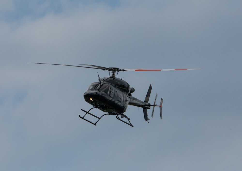 a helicopter flying through a cloudy blue sky