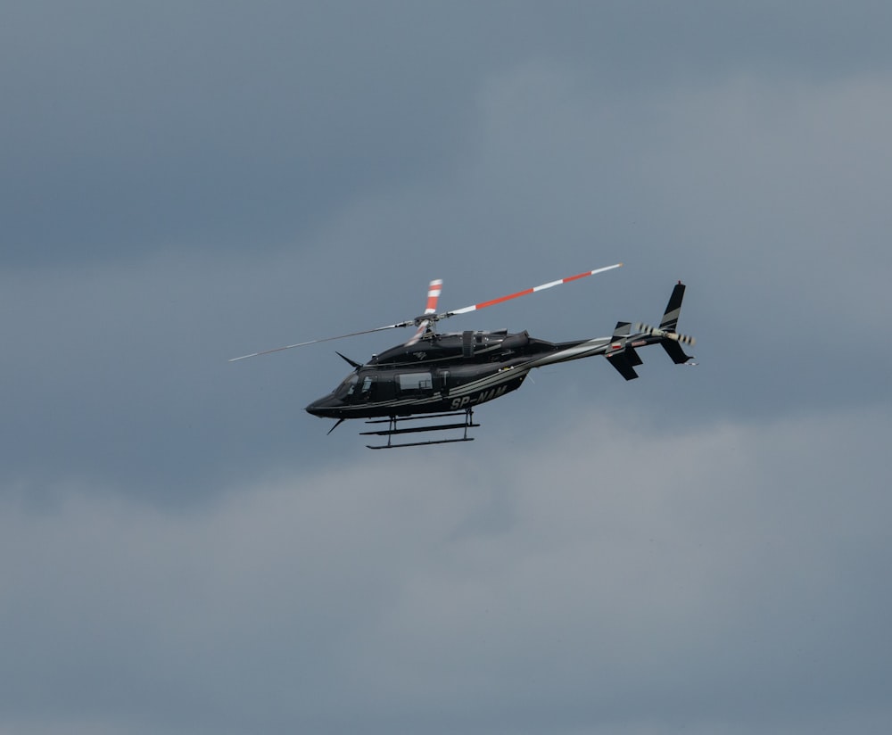 a helicopter flying through a cloudy sky with two propellers