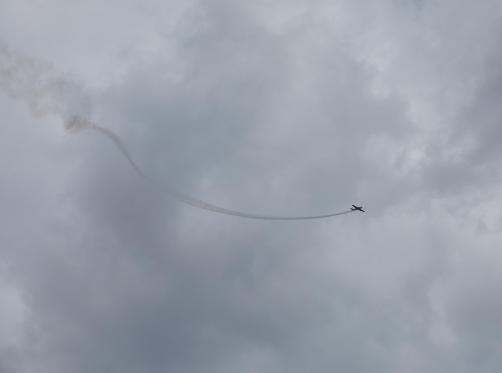 a small airplane flying through a cloudy sky