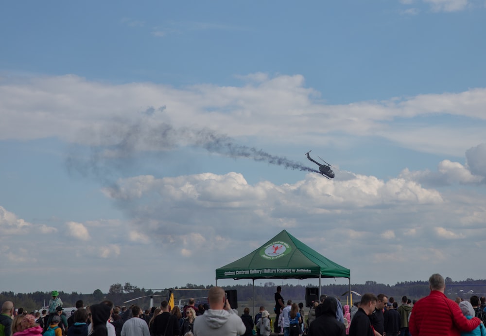 a group of people watching a plane fly by