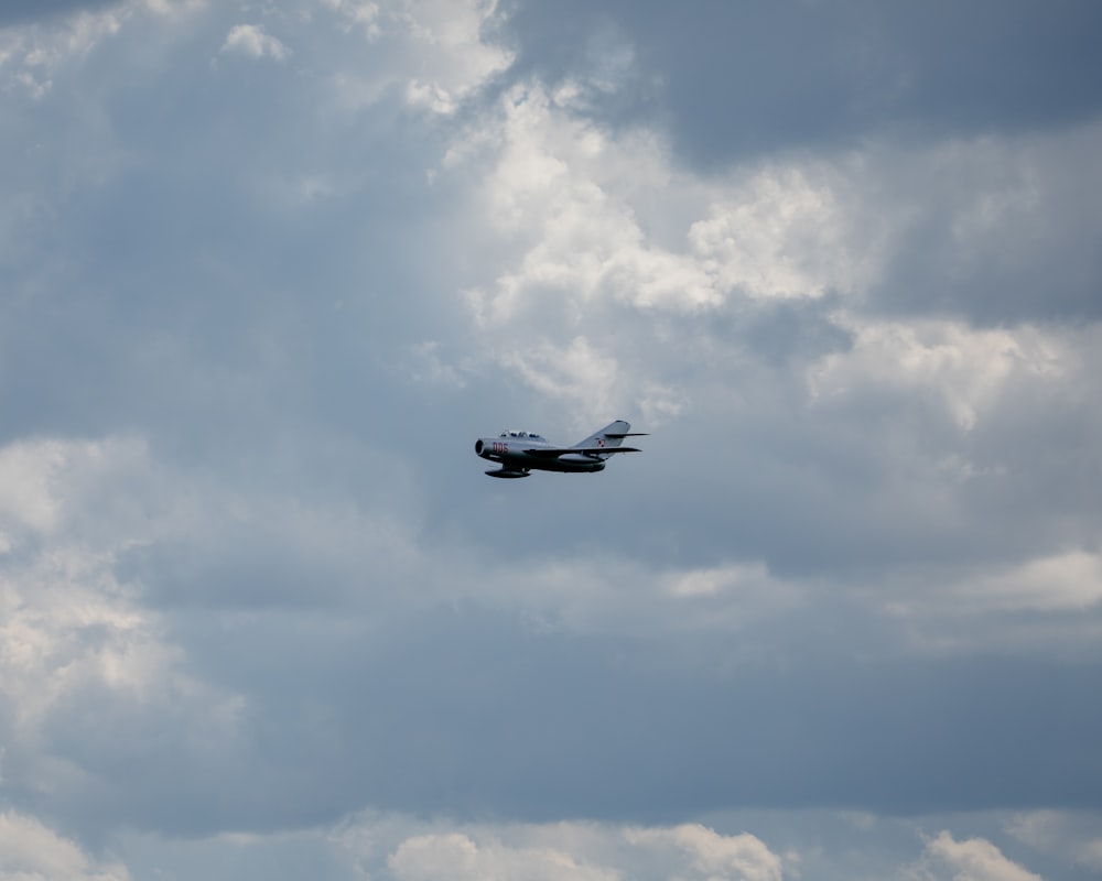 a plane flying through a cloudy sky
