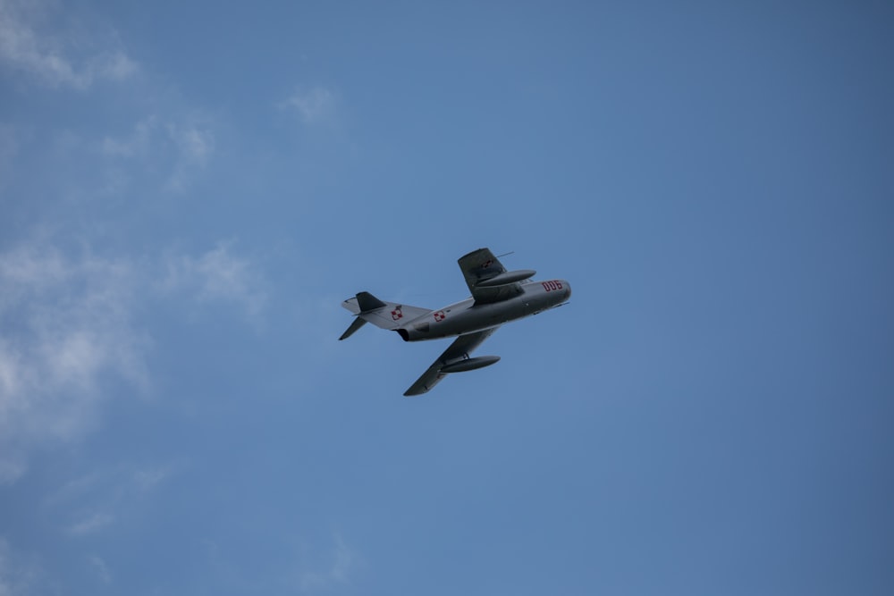 an airplane flying in the sky with a blue sky background