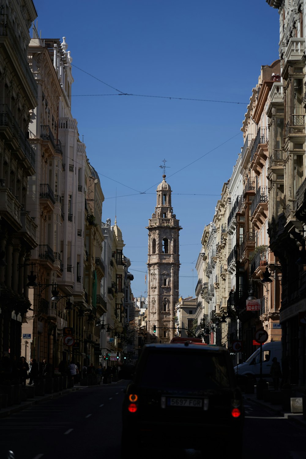 a car driving down a street next to tall buildings