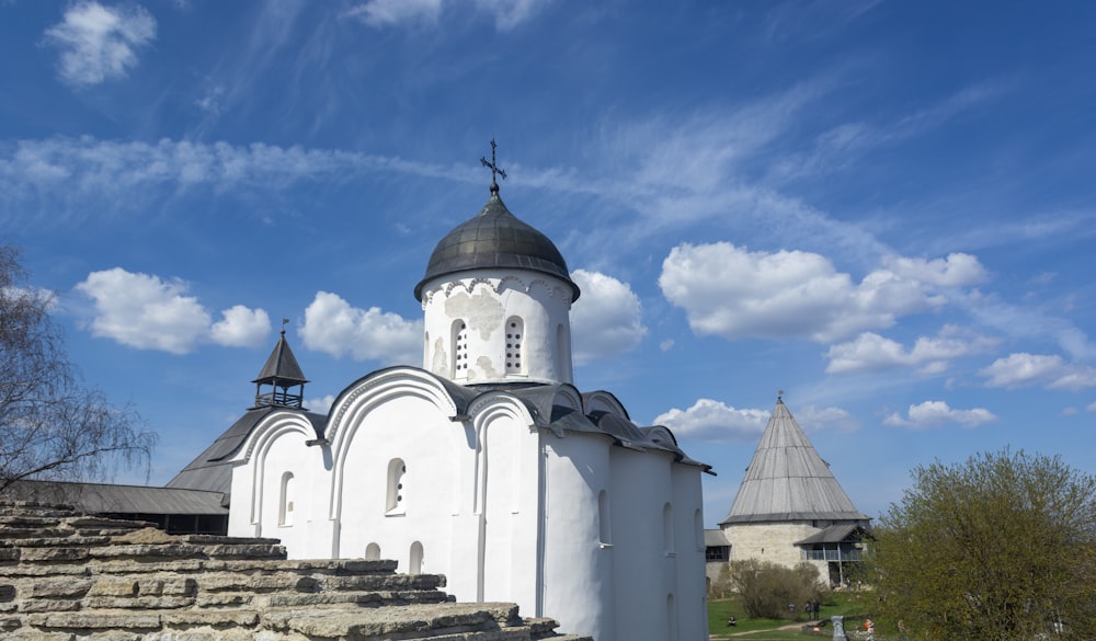 a white church with a steeple on a sunny day