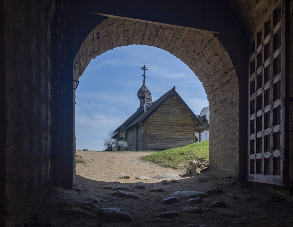 an old wooden building with a cross on top of it