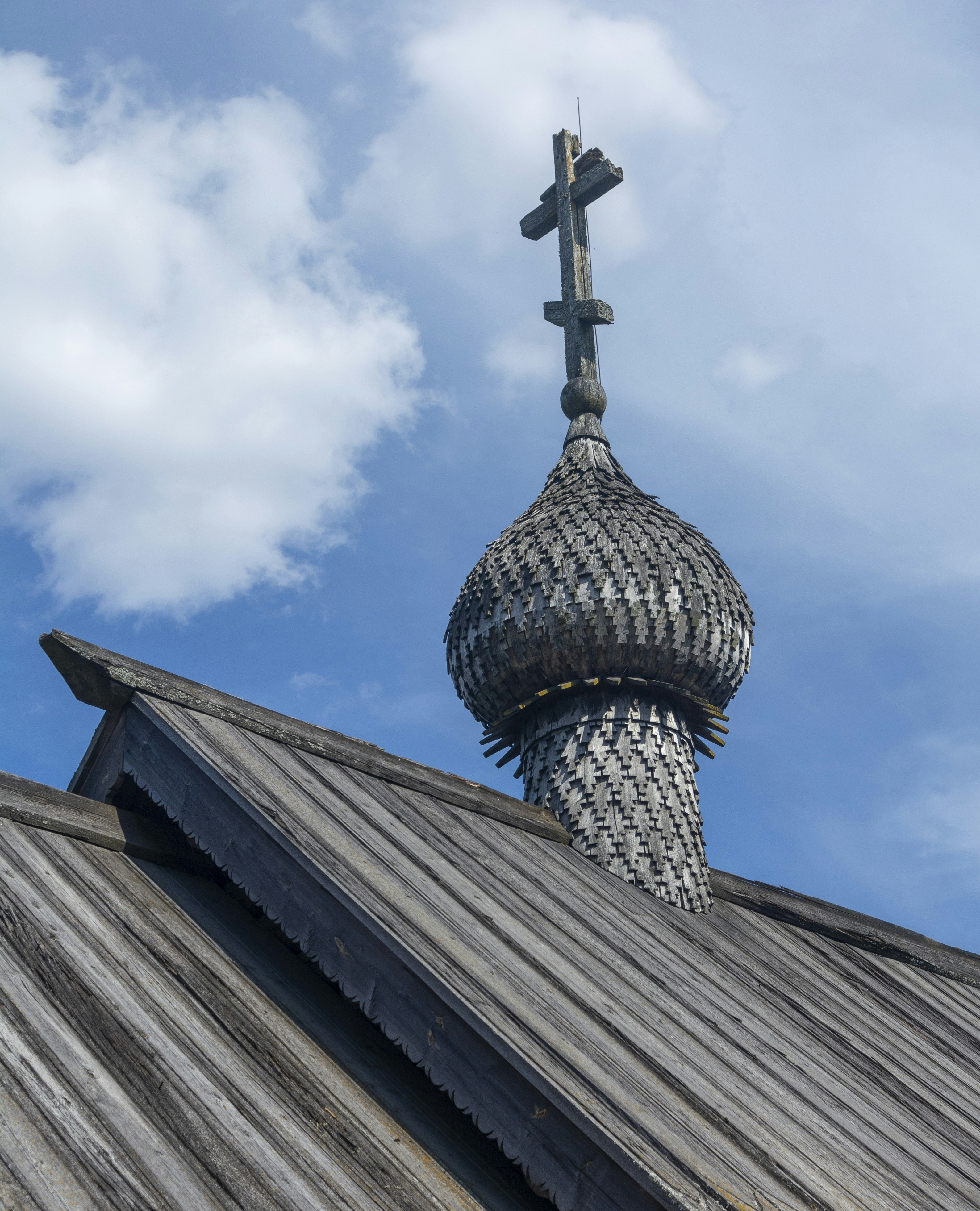 a cross on top of a building with a sky background