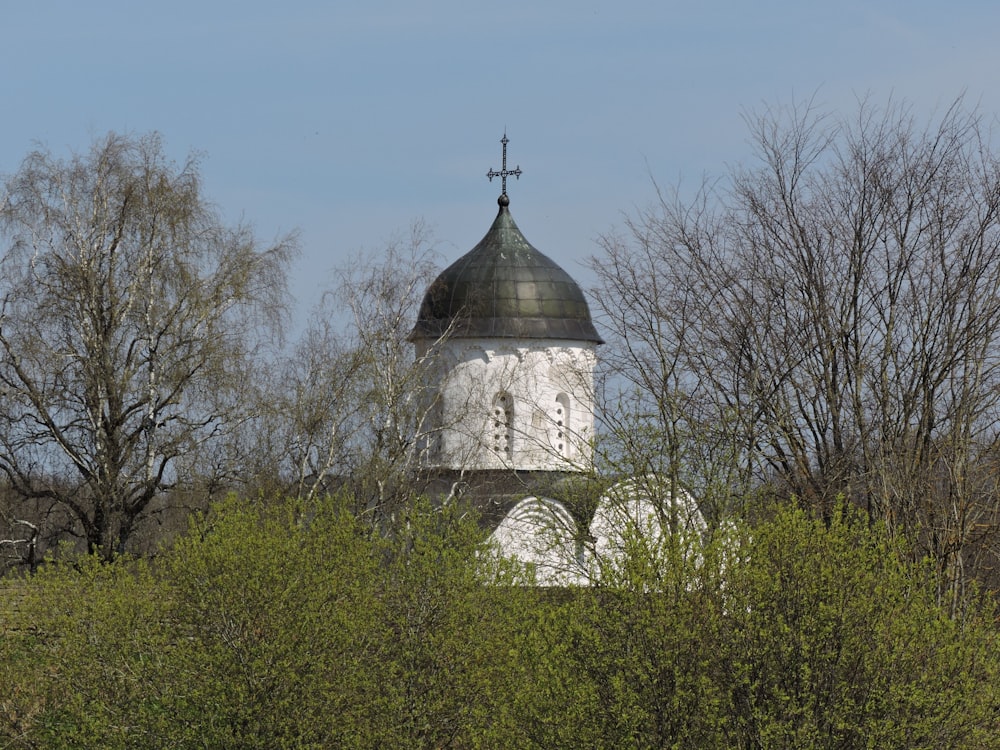 a white and black tower with a cross on top of it