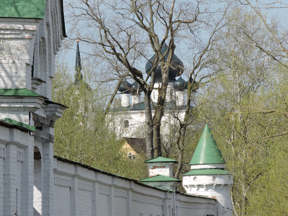 Un edificio bianco con un tetto verde e una torre dell'orologio