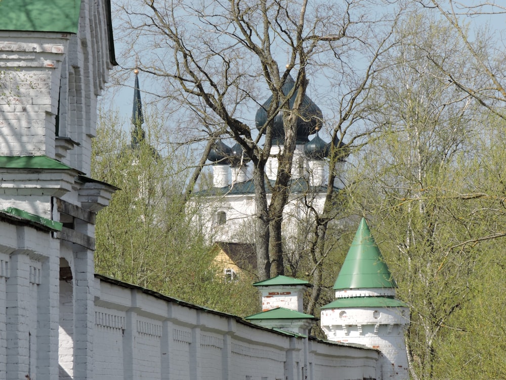 a white building with a green roof and a clock tower