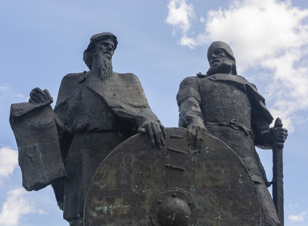 una statua di due uomini che reggono uno scudo