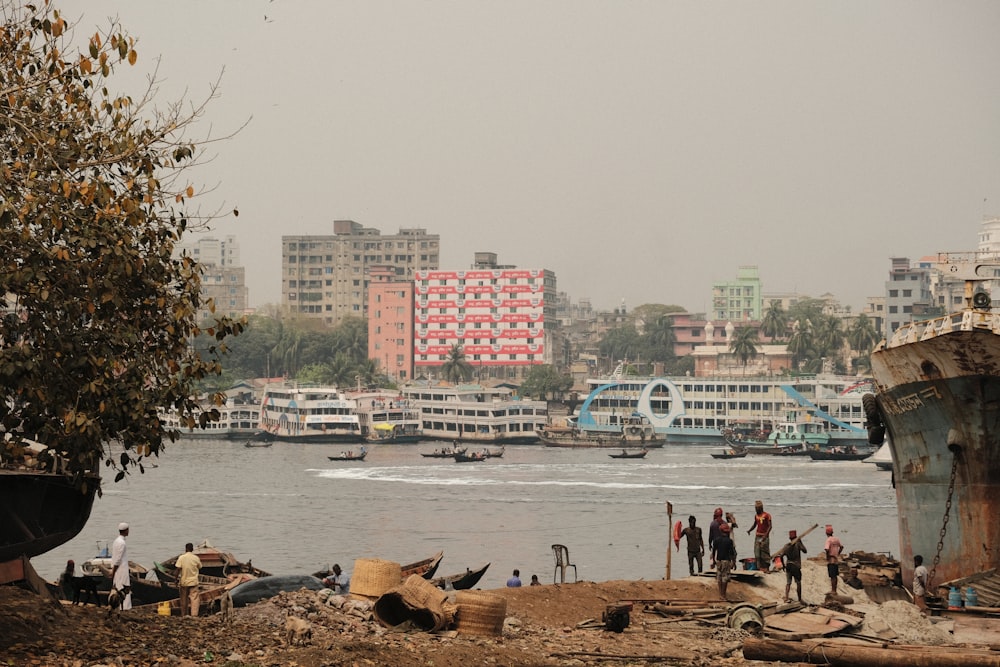 a group of people standing on a beach next to a body of water