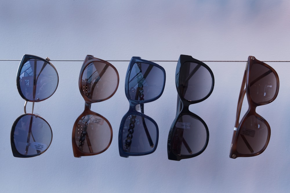 a line of sunglasses hanging on a clothes line