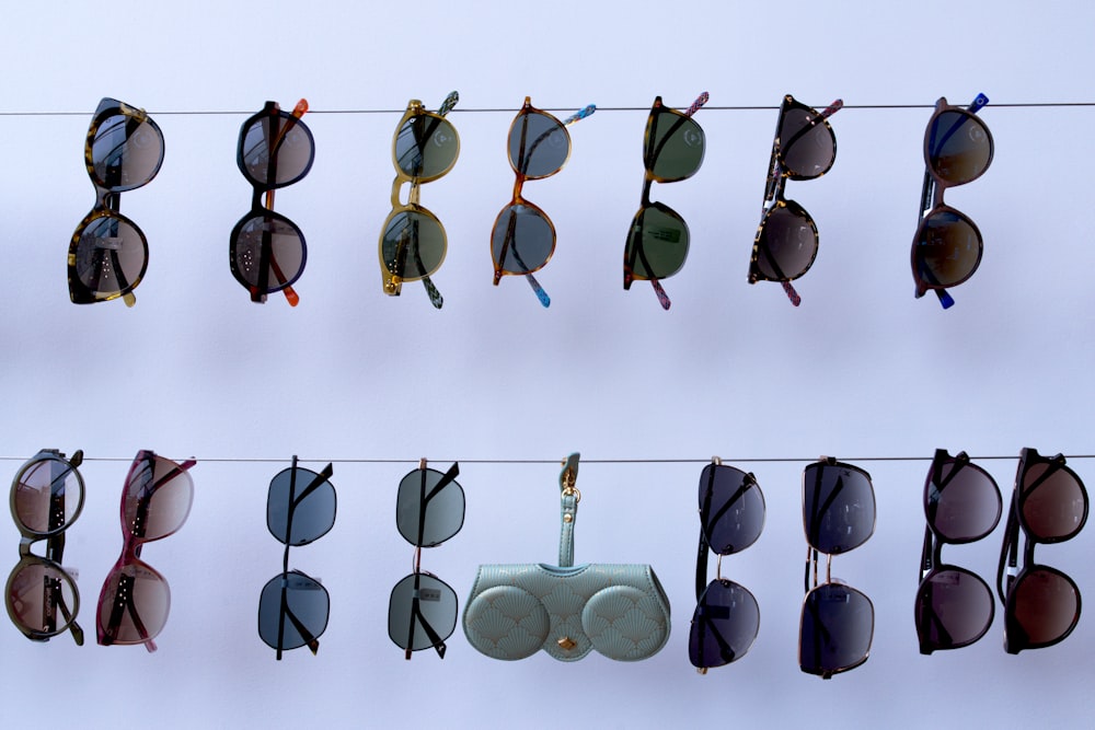 a line of sunglasses hanging on a clothes line