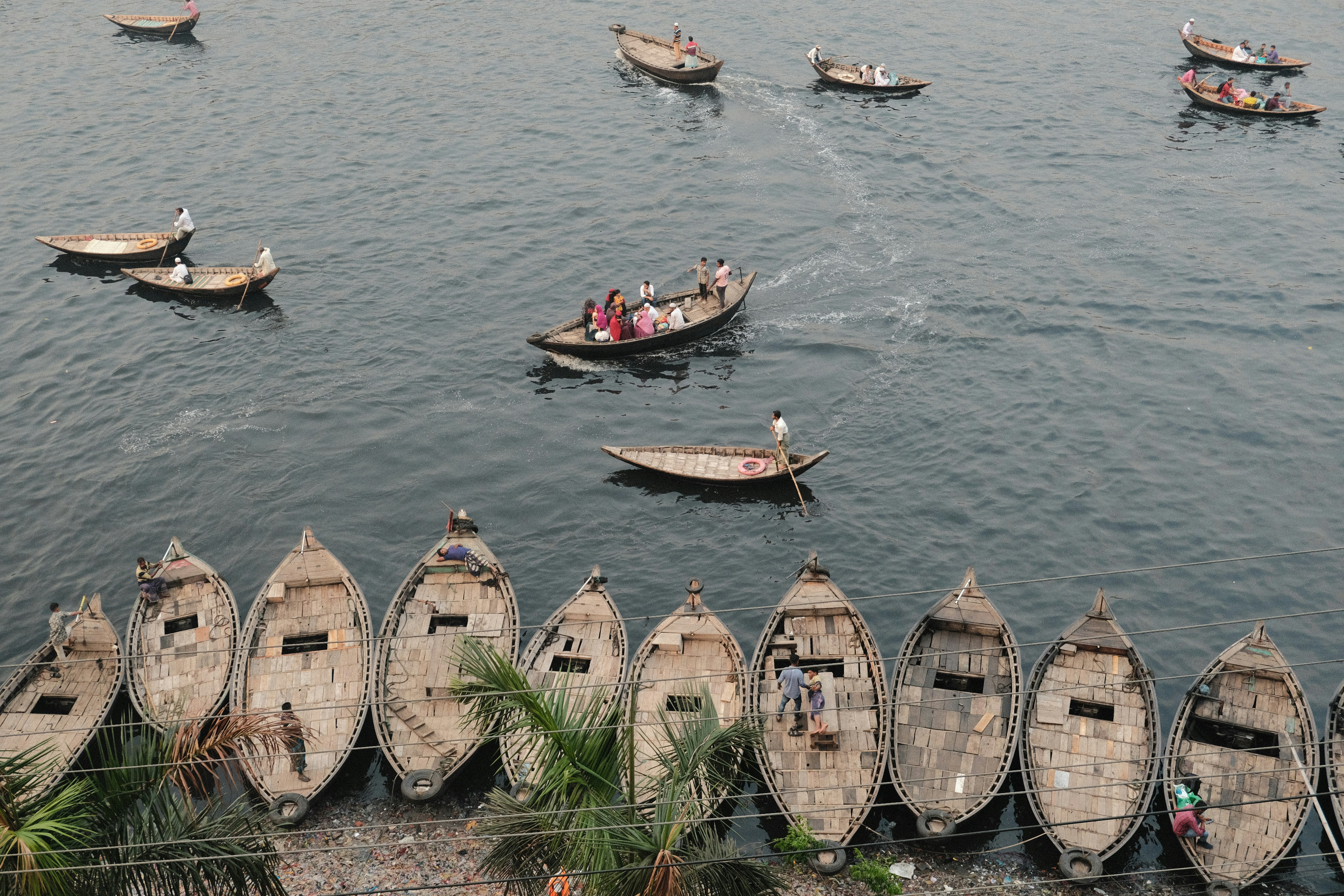 a number of small boats in a body of water, Buriganga River in Dhaka, Bangladesh. March 2024. SOOC JPEG.
