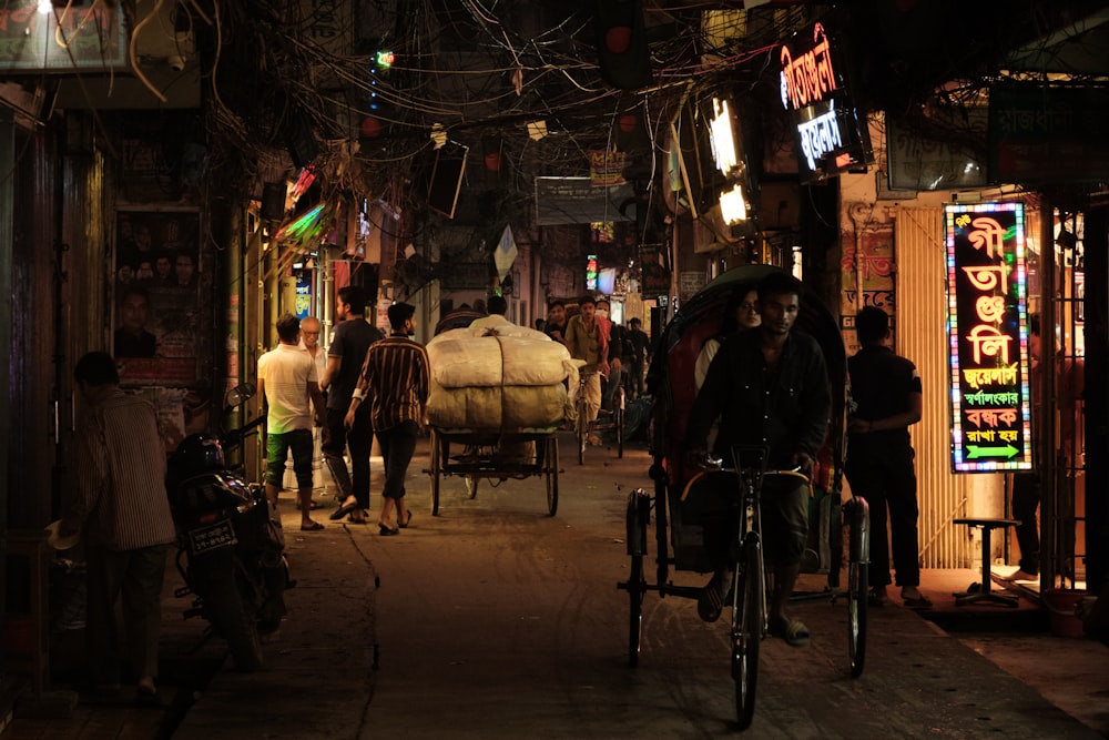 a group of people walking down a street at night