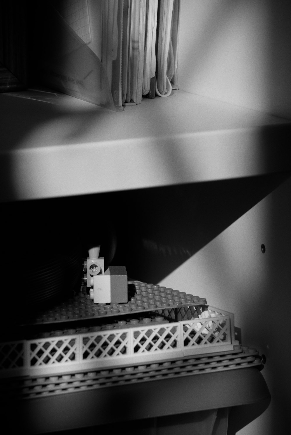 a black and white photo of a shelf in a room