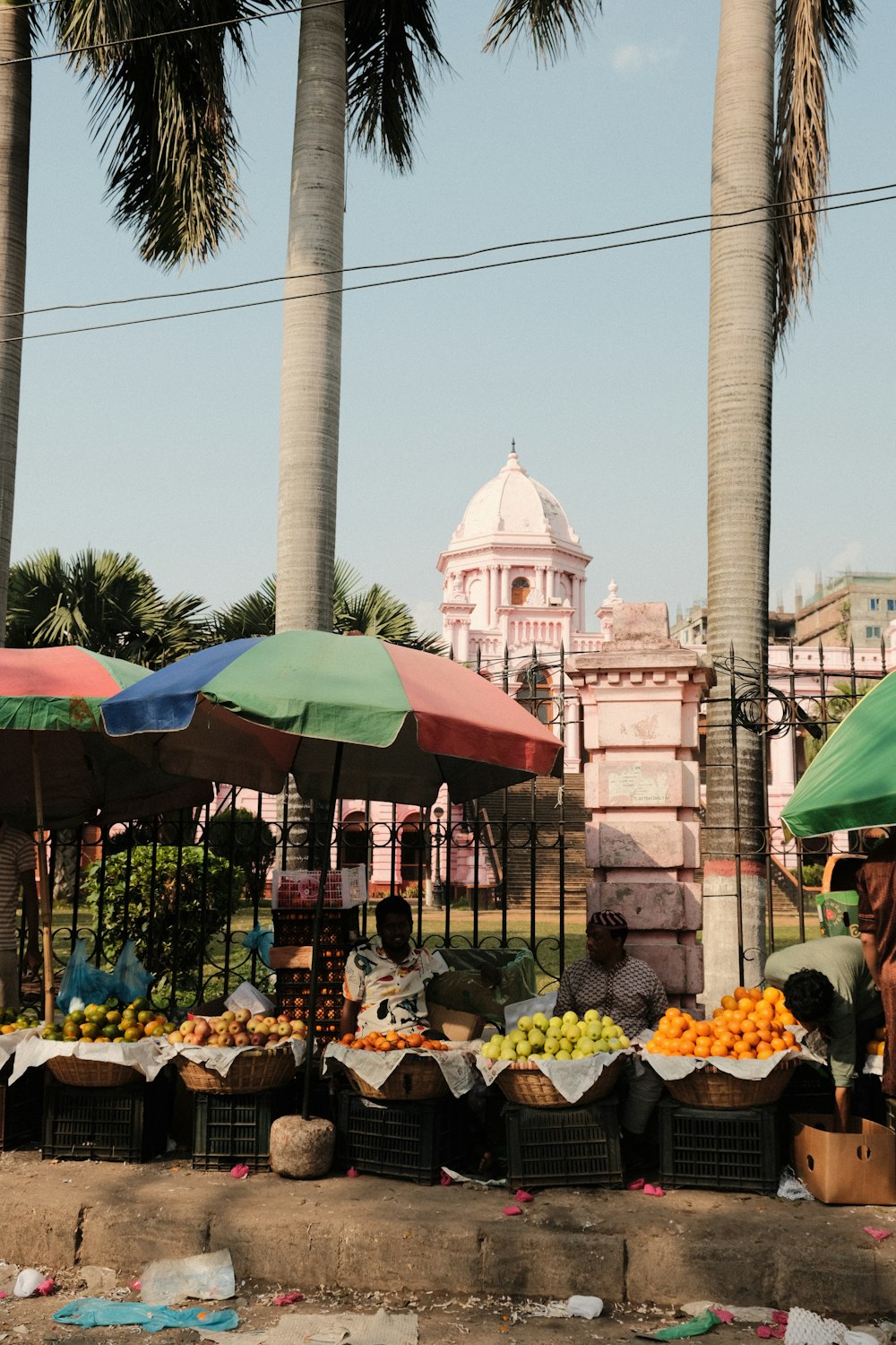 a fruit stand with a lot of fruit under umbrellas