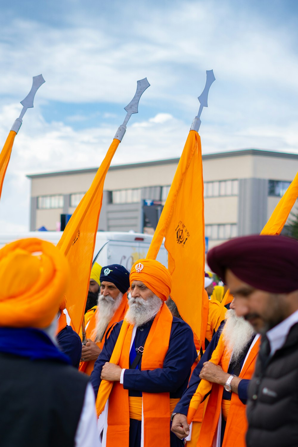 a group of men standing next to each other holding orange flags