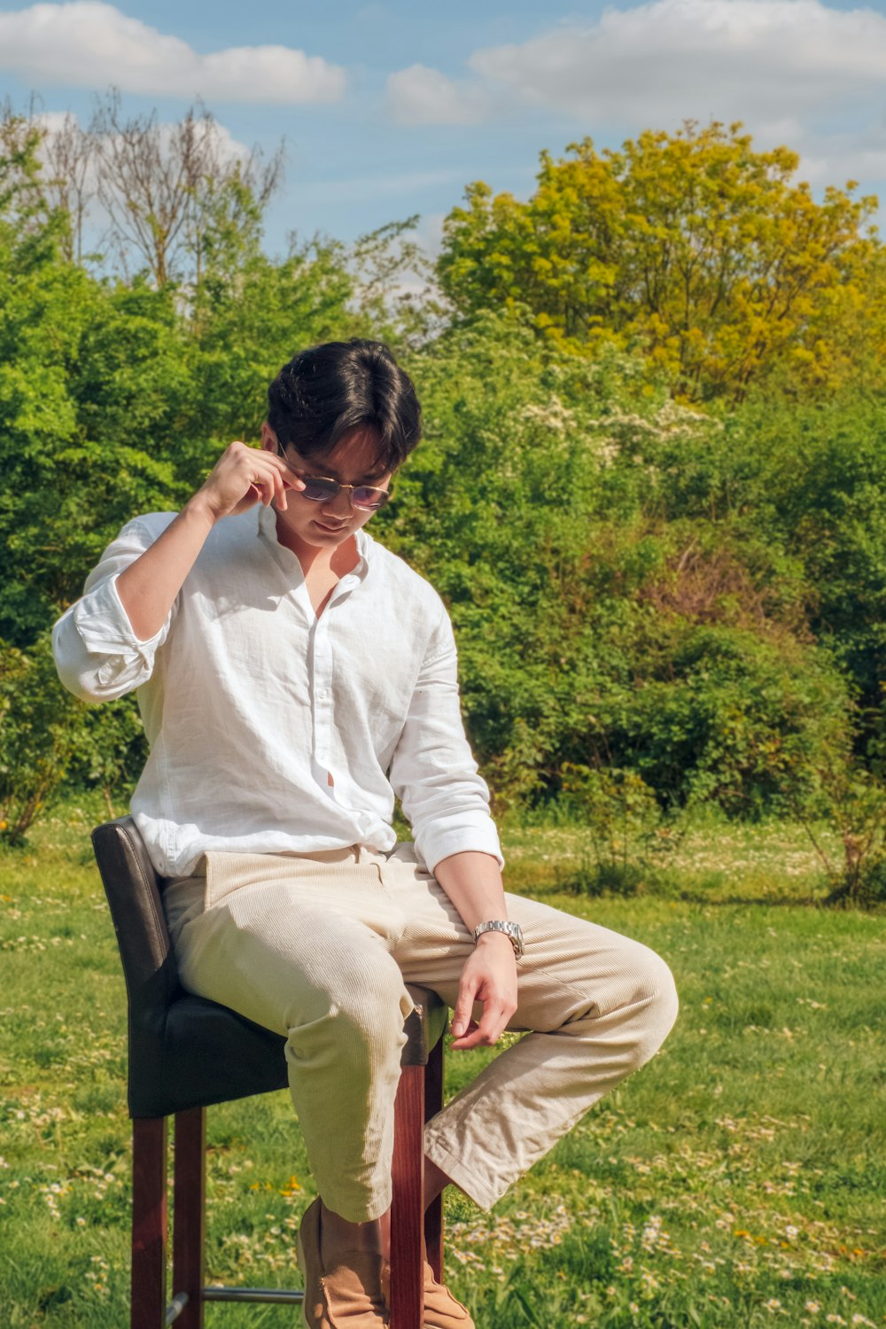 a man sitting on top of a chair in a field