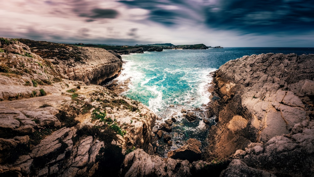 a view of the ocean from a rocky cliff