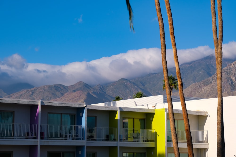 a view of a multi - colored building with mountains in the background
