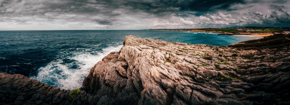 a large body of water sitting next to a rocky cliff