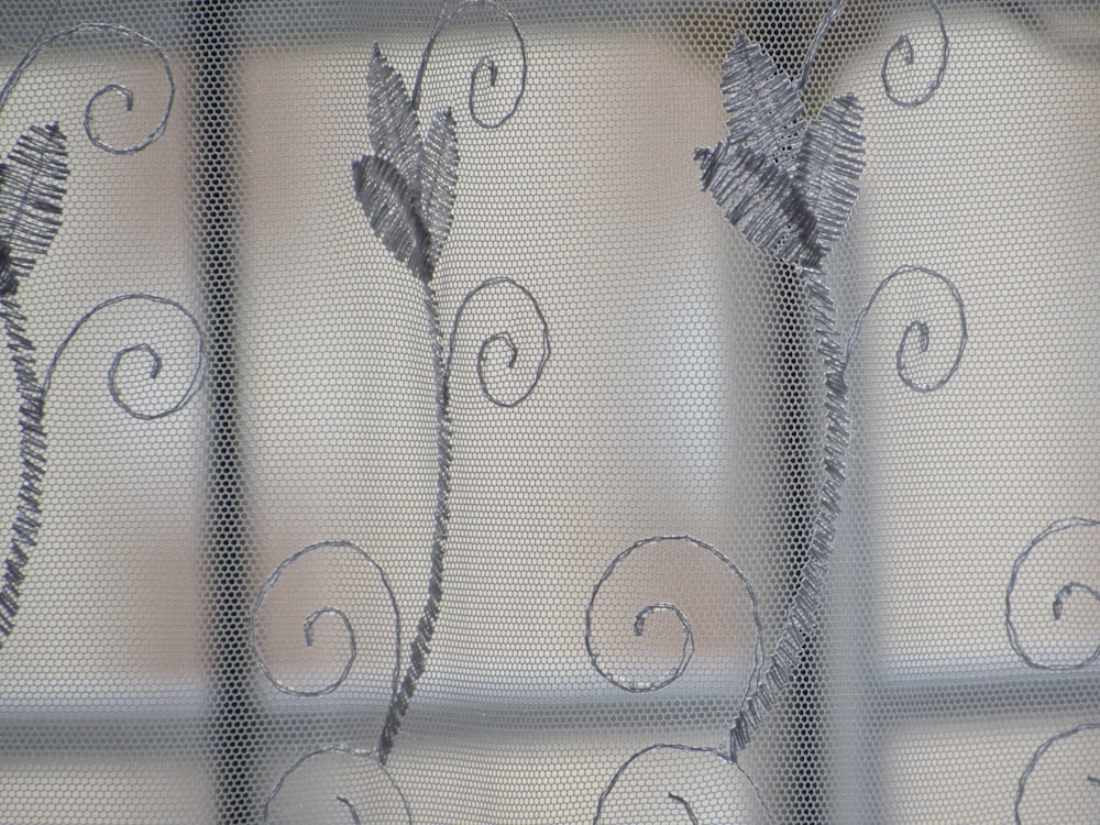 a close up of a curtain with a flower on it