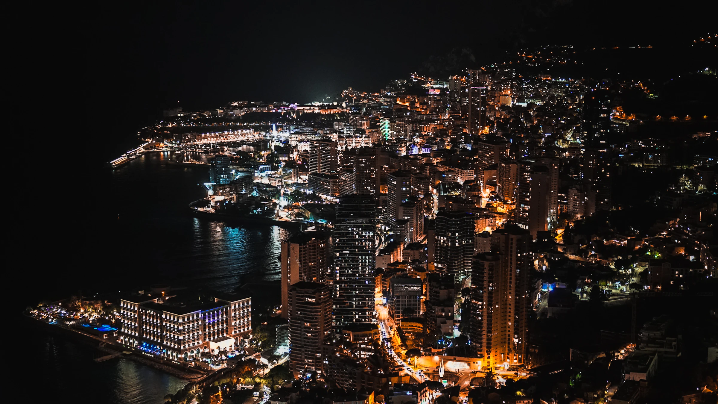Monaco coastline lights glowing against the deep evening sea