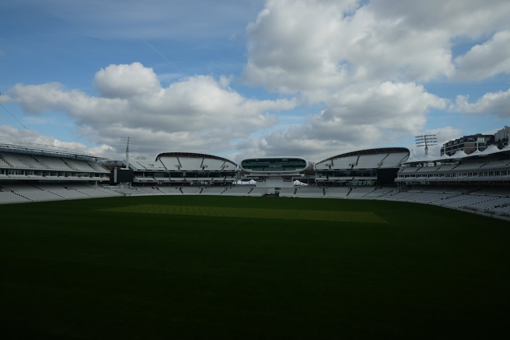 a large empty stadium with a green field in front of it