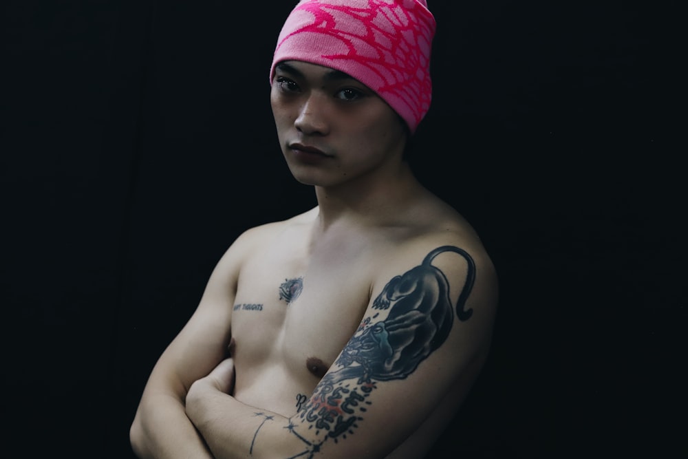 a shirtless man with a pink towel on his head