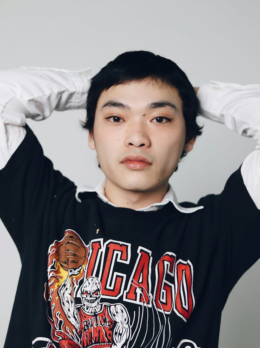 a young man is posing with his hands on his head