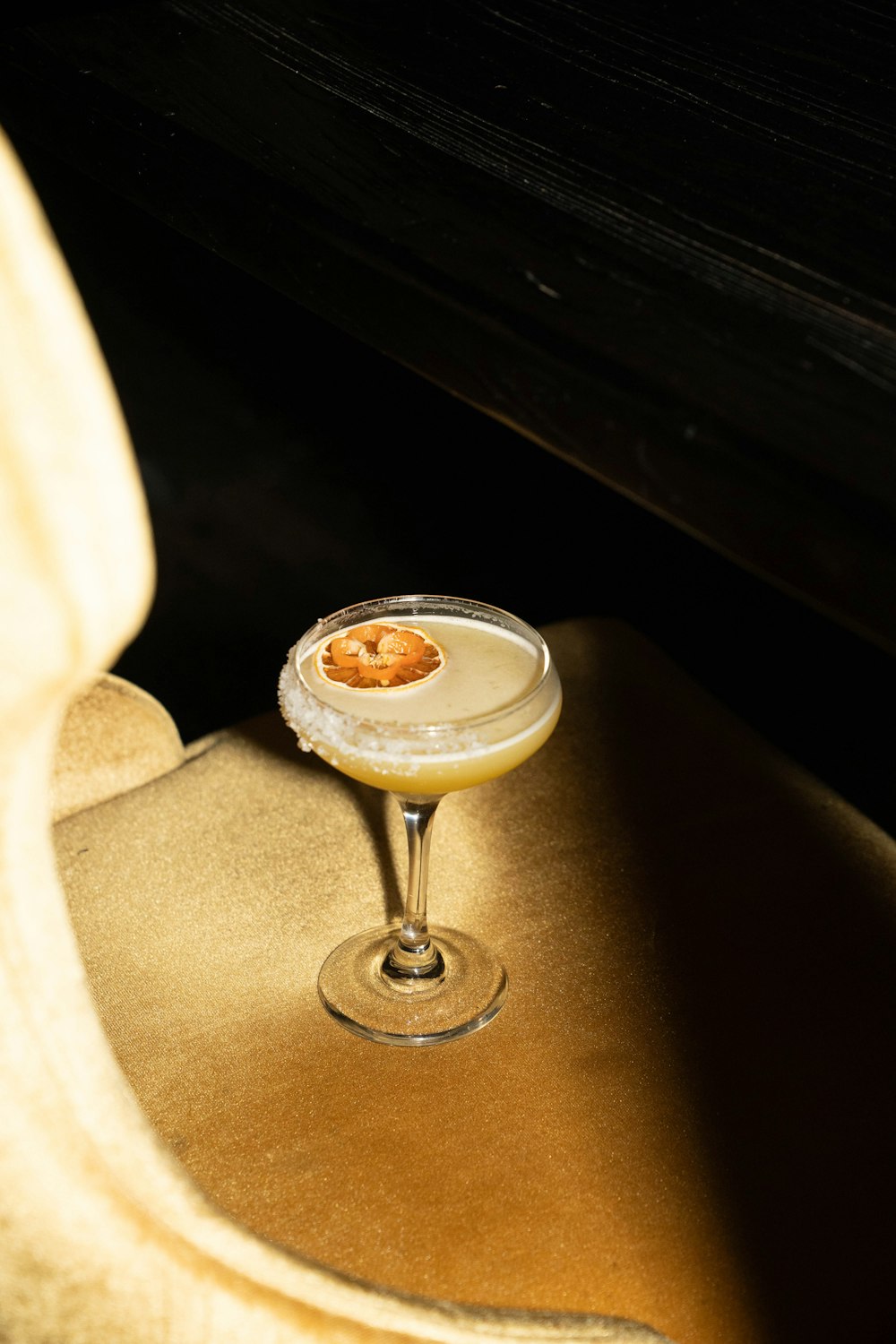 a drink sitting on top of a chair next to a piano