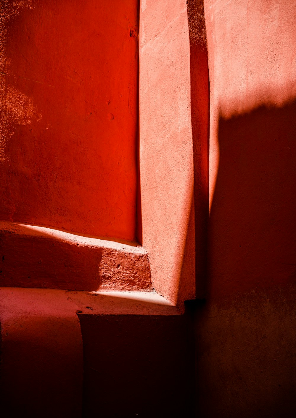 the shadow of a window on a red wall