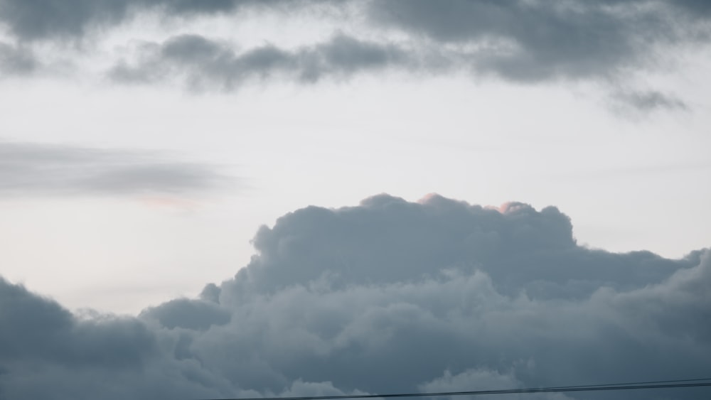 a plane flying through a cloudy sky on a cloudy day