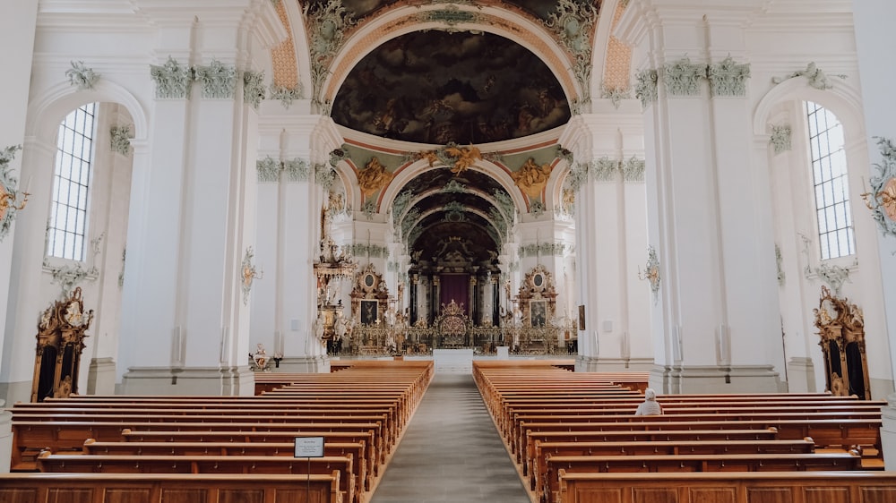 an empty church with wooden pews in the middle