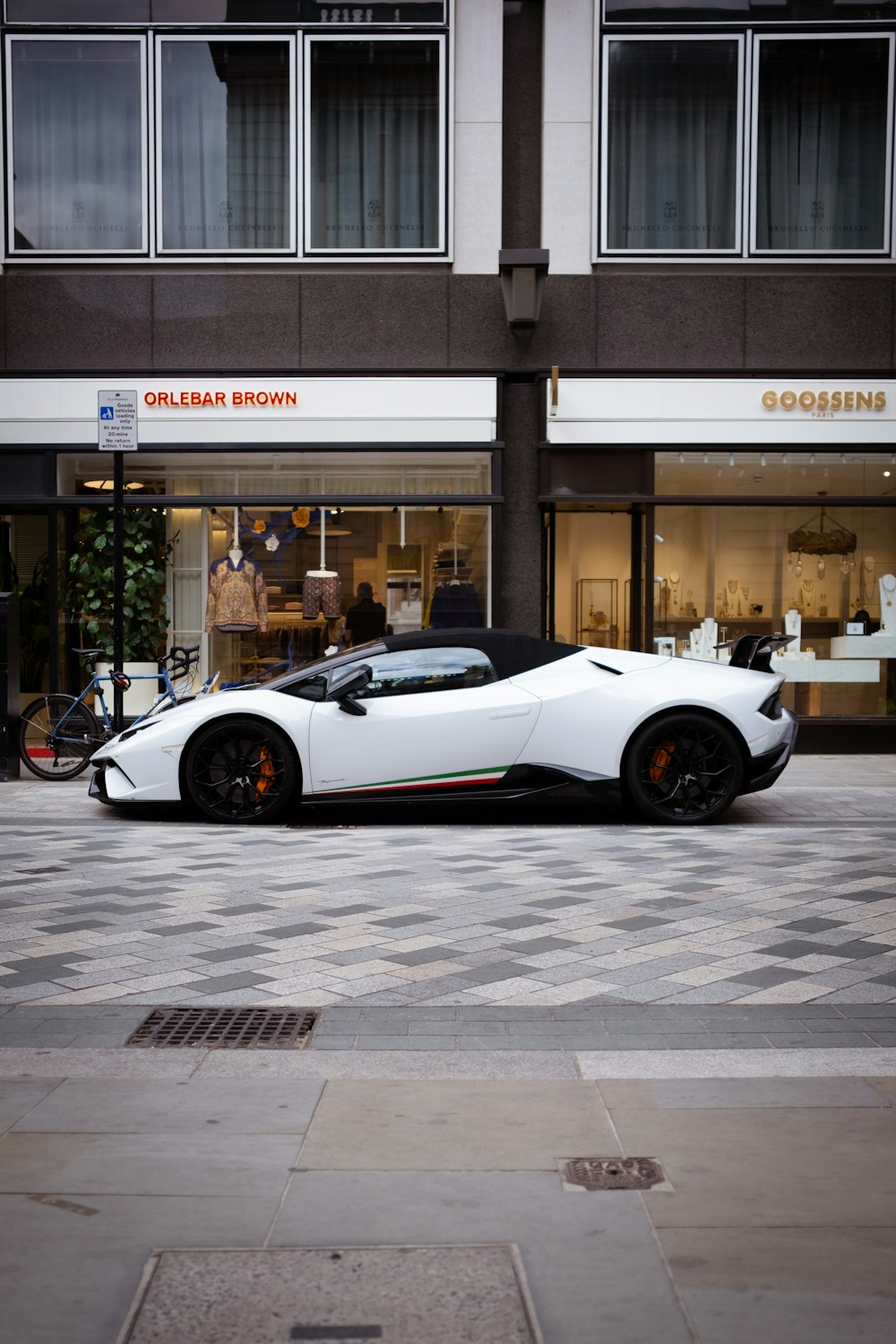 a white sports car parked in front of a building