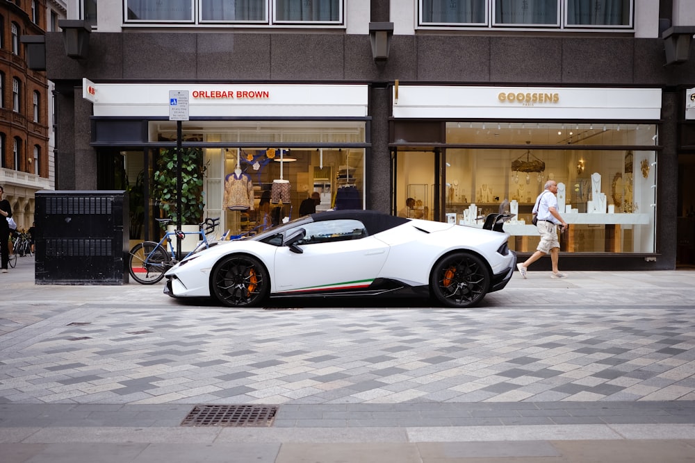 a white sports car parked in front of a store